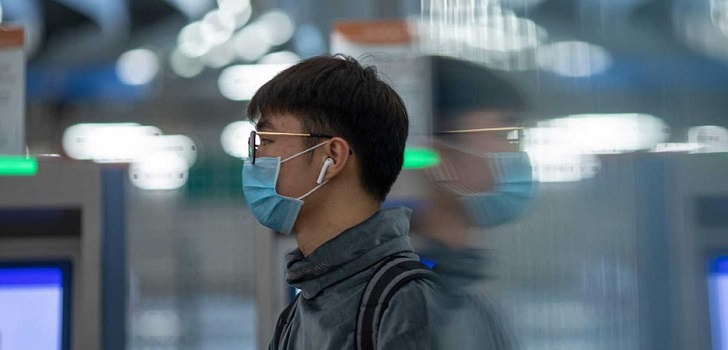 Ciudadanos chino con una mascarilla China anuncia su primera vacuna para combatir el coronavirus